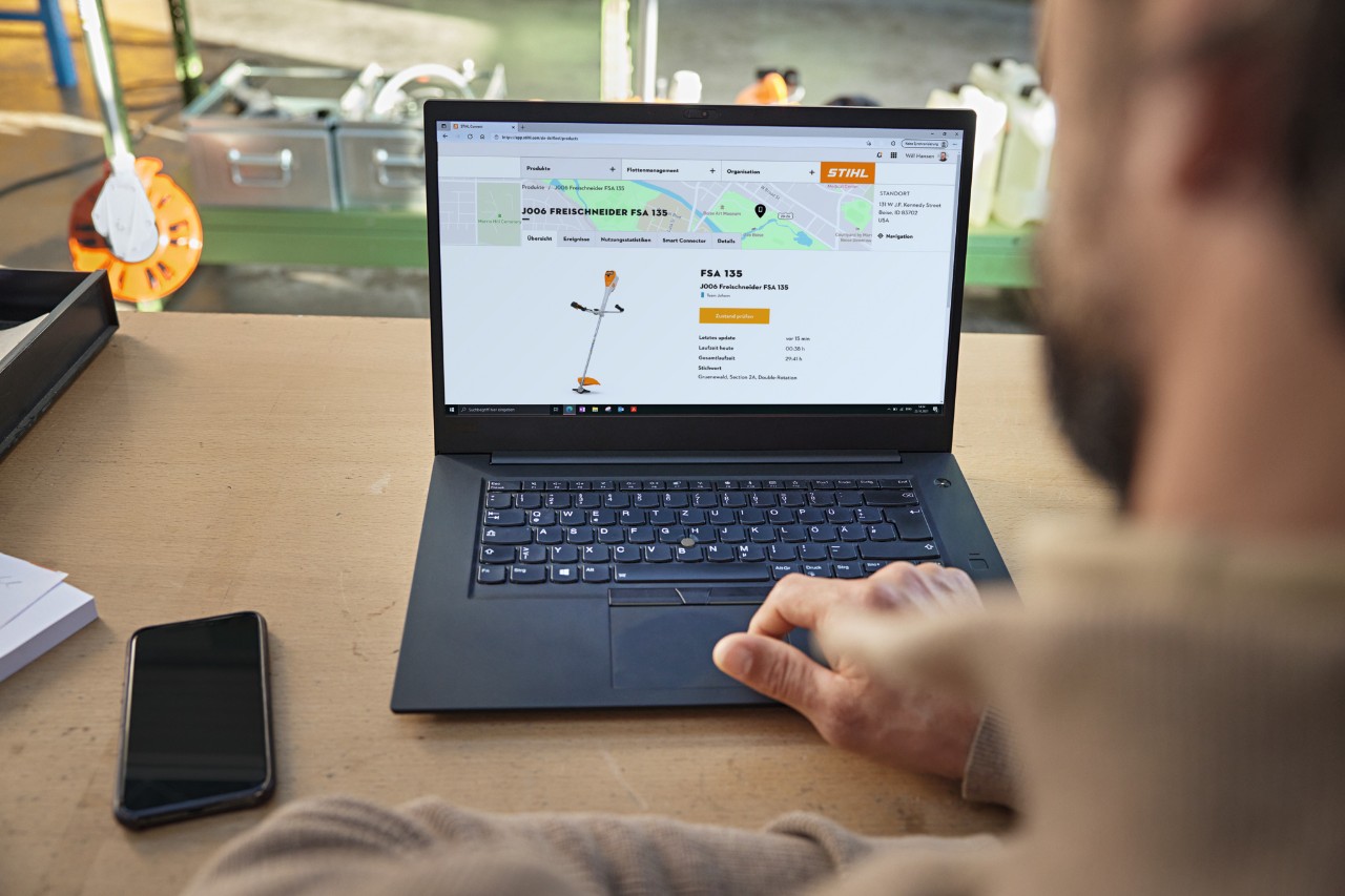 Eine Person nutzt an einem Laptop das STIHL connected Portal und schaut sich dort verschiedene Gerätedaten an. 