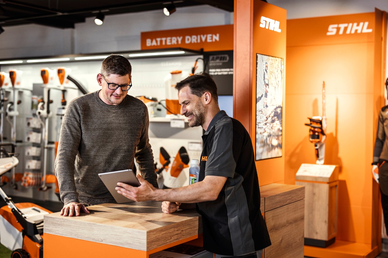 Ein STIHL Händler berät einen Kunden in einem Showroom