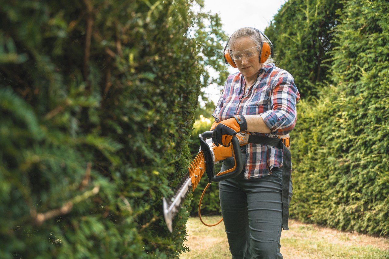 Chefgärtnerin Aldetha Raymond schneidet mit einer Akku-Heckenschere STIHL HSA 130 eine Hecke