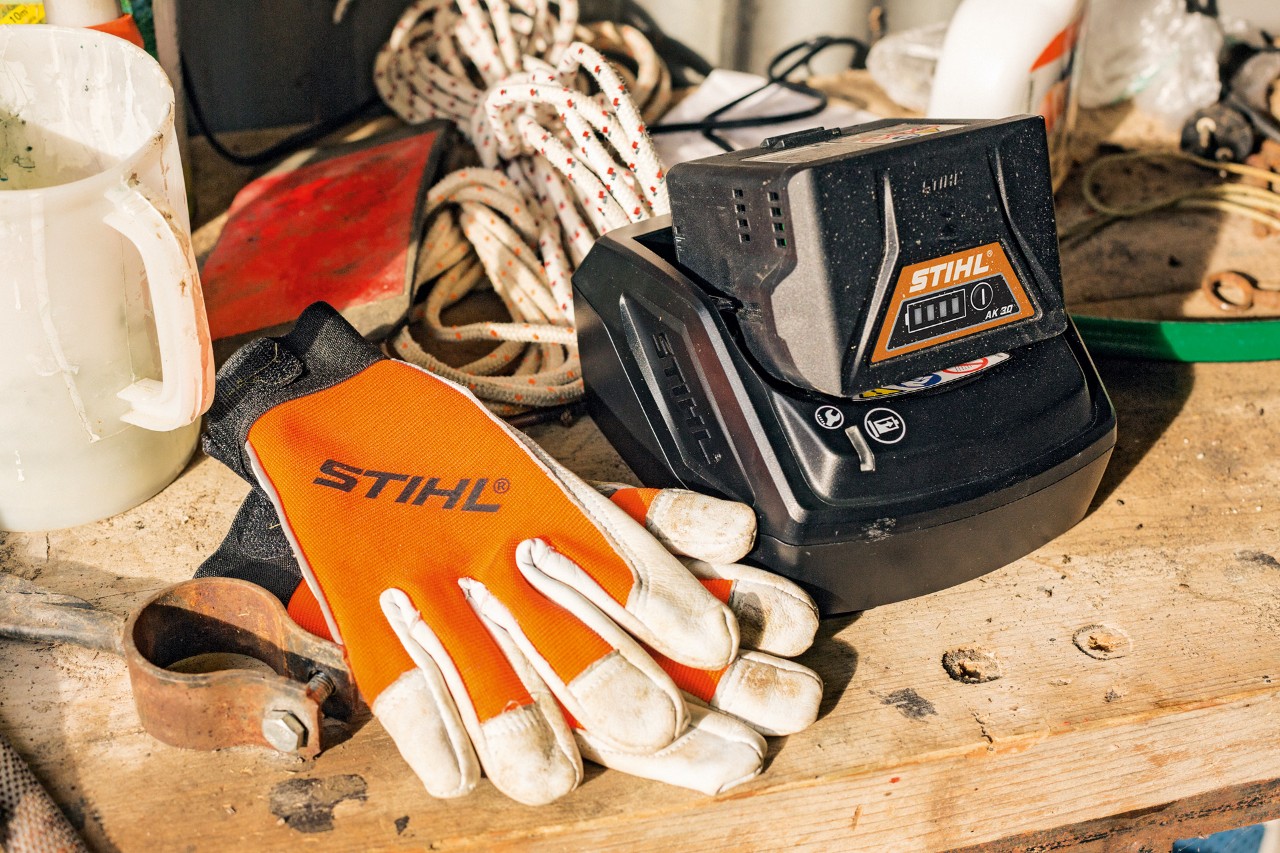 Akku und Handschuhe liegen auf einer Arbeitsfläche