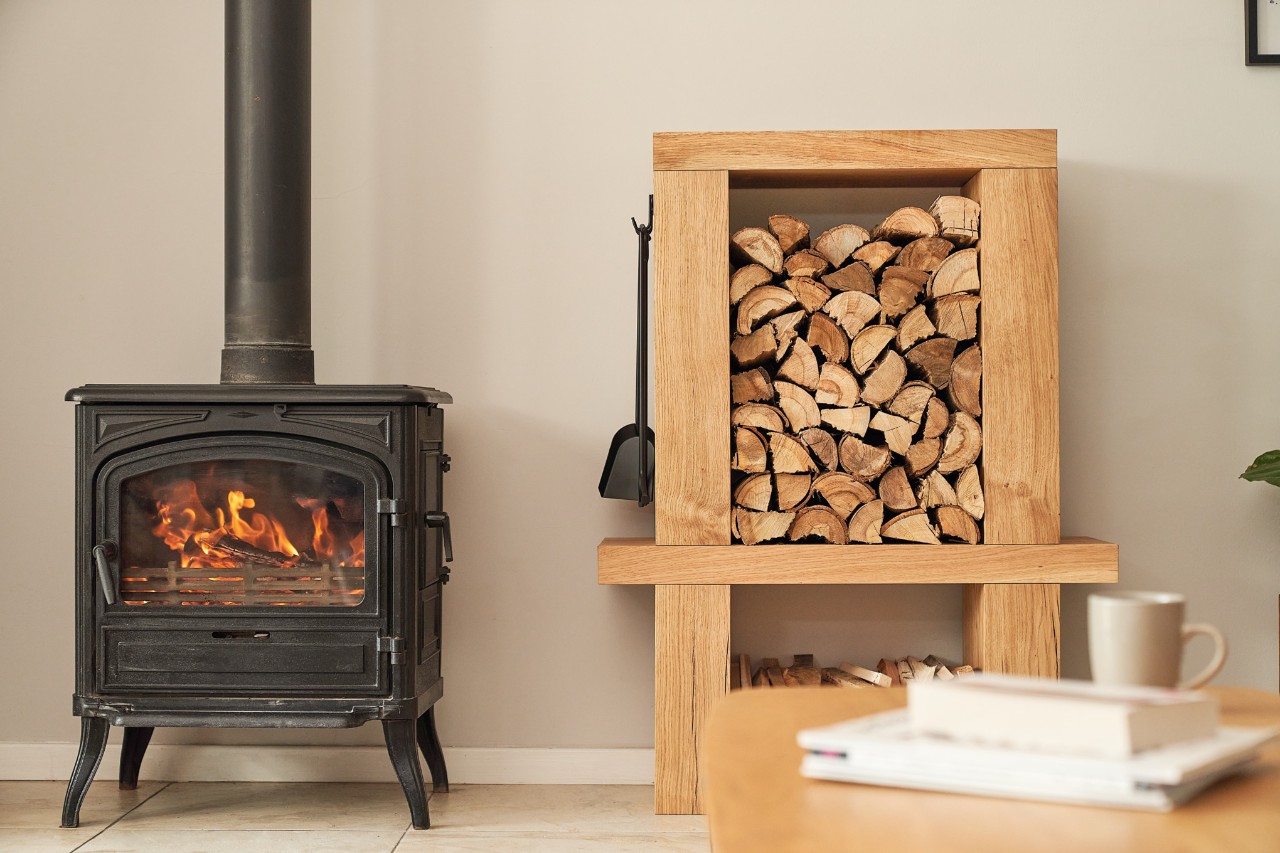 Kaminholzregal innen neben einem brennenden Kamin