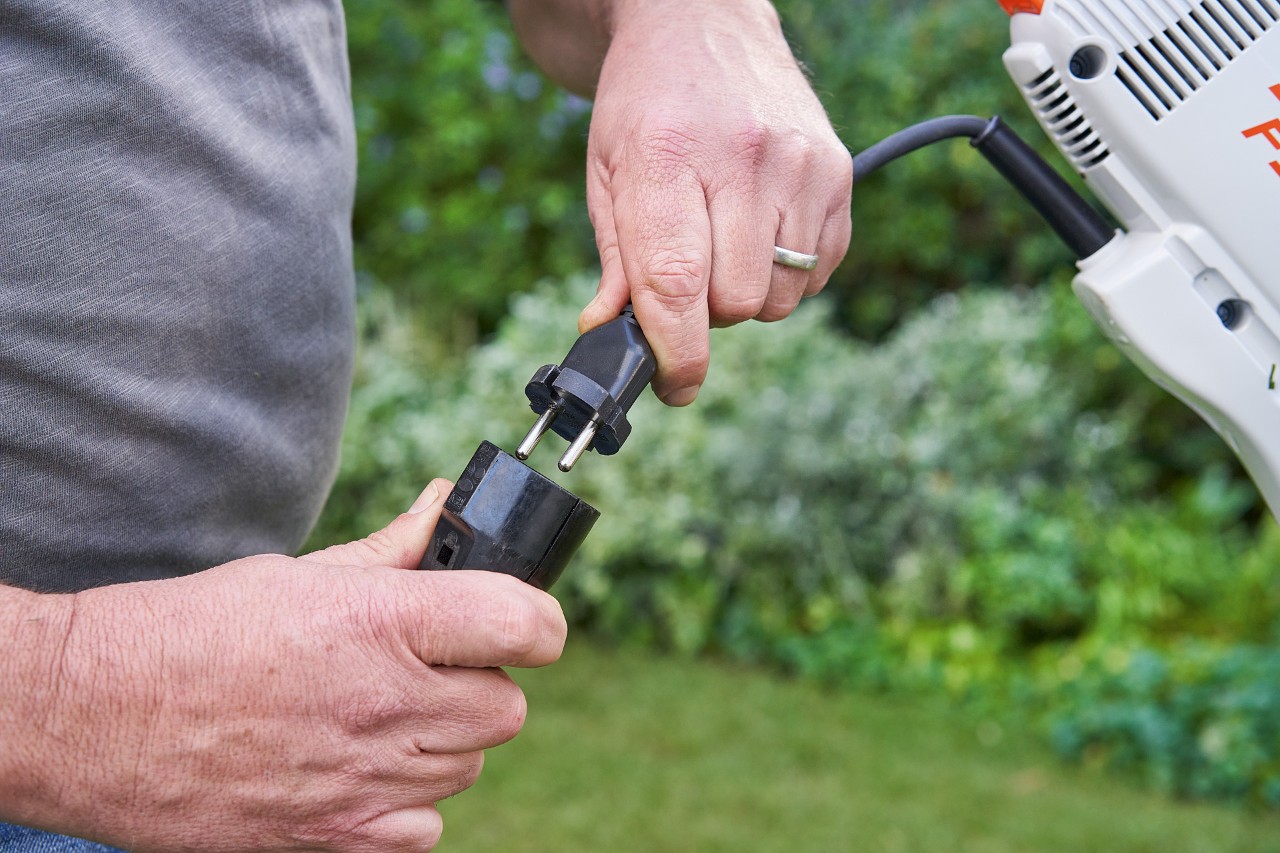 Mann mit Schutzhandschuhen betätigt den Schalthebel der Elektro-Motorsense STIHL FSE 60, um sie zu starten