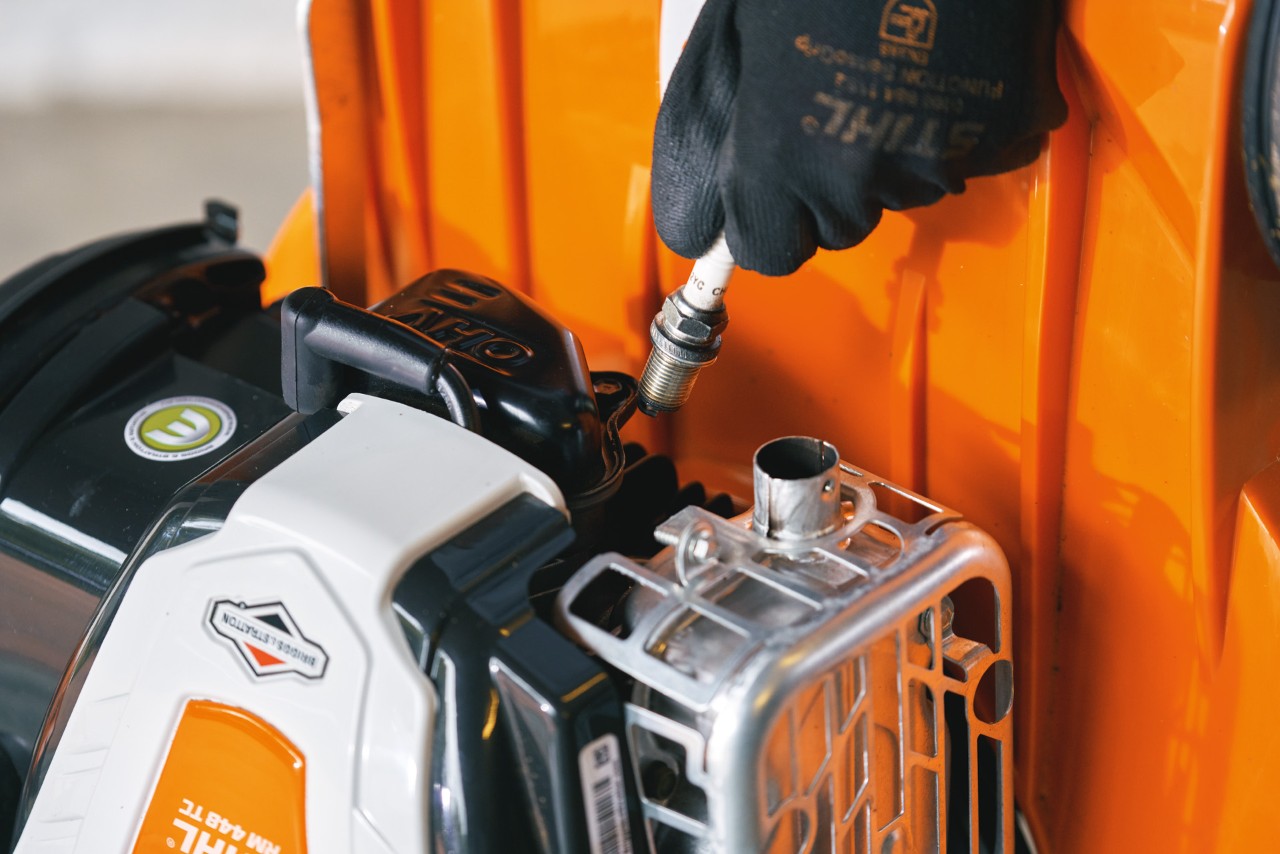 Zündkerze von STIHL Benzin-Rasenmäher RM 448 T-C wird ausgewechselt