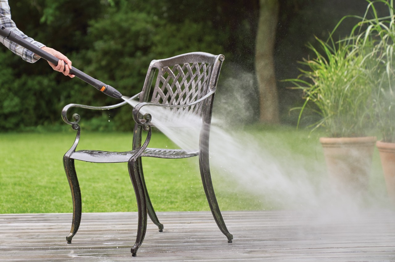 STIHL Hochdruckreiniger RE 130 plus reinigt Gartenstuhl aus Metall