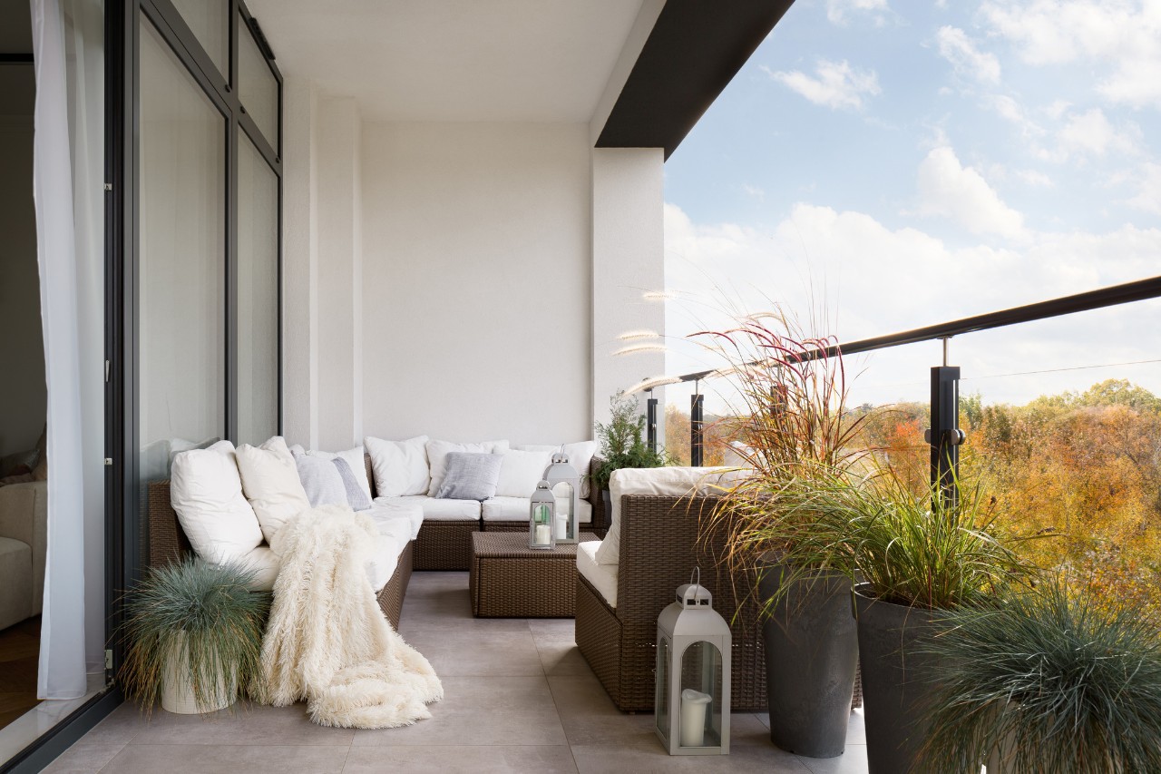 Dachterrasse mit gepolsterter Sitzecke, Laternen und Pflanztrögen