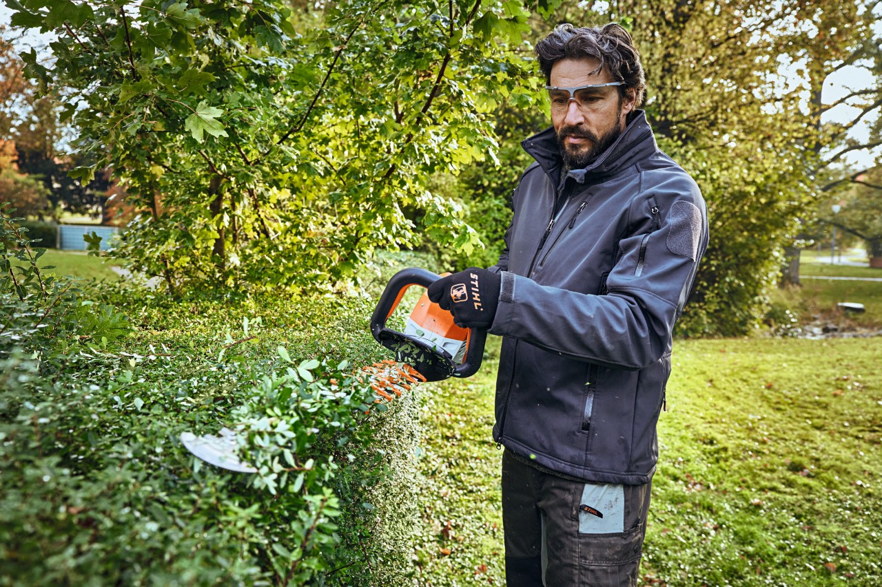 Nahaufnahme, wie mit der Akku-Heckenschere STIHL HSA 26 ein Buchsbaum geschnitten wird