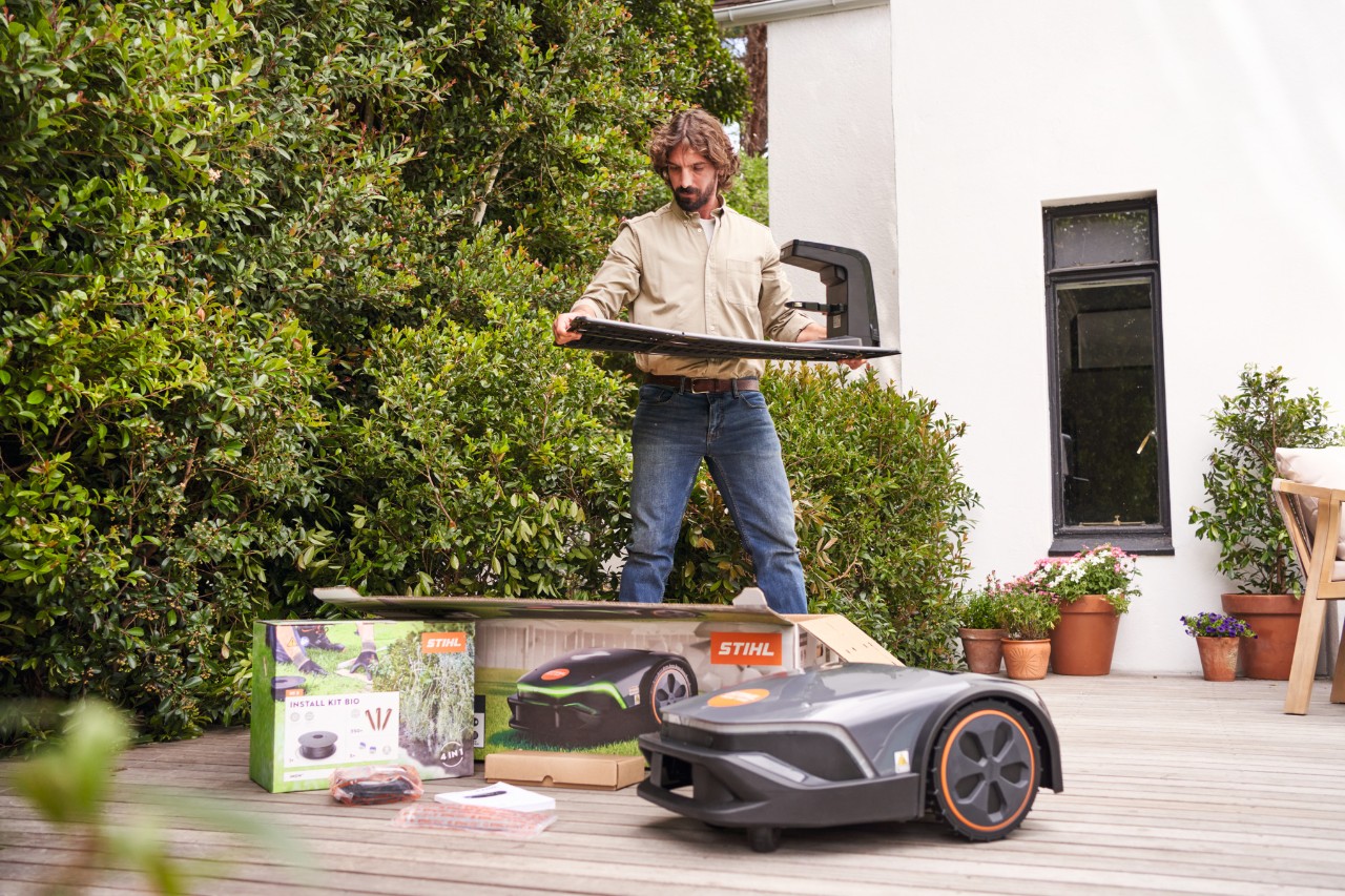 Ein Mann auf einer Terrasse packt einen iMOW aus