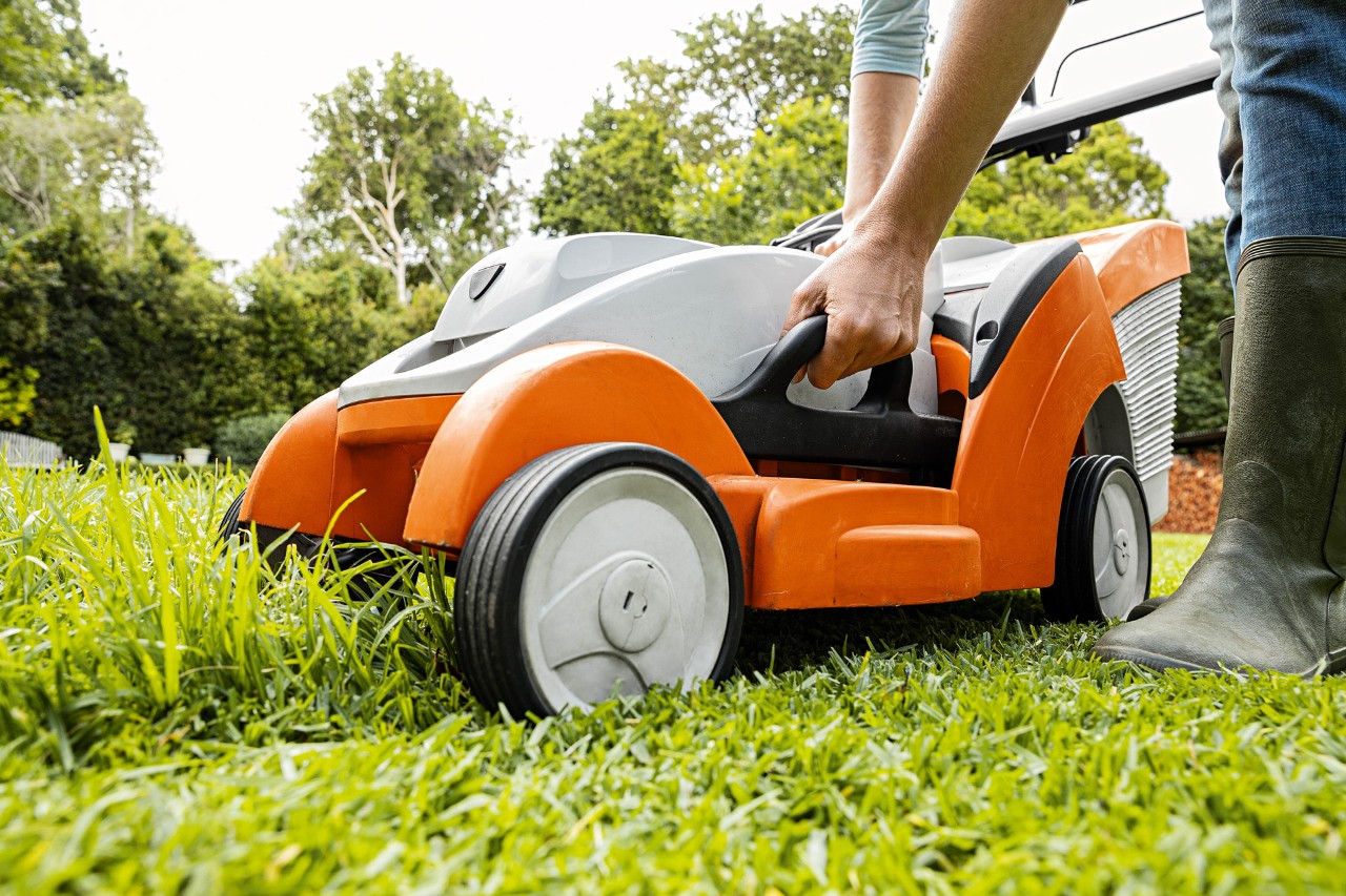 Frau stellt am STIHL Akku-Rasenmäher RMA 339 C die Schnitthöhe ein