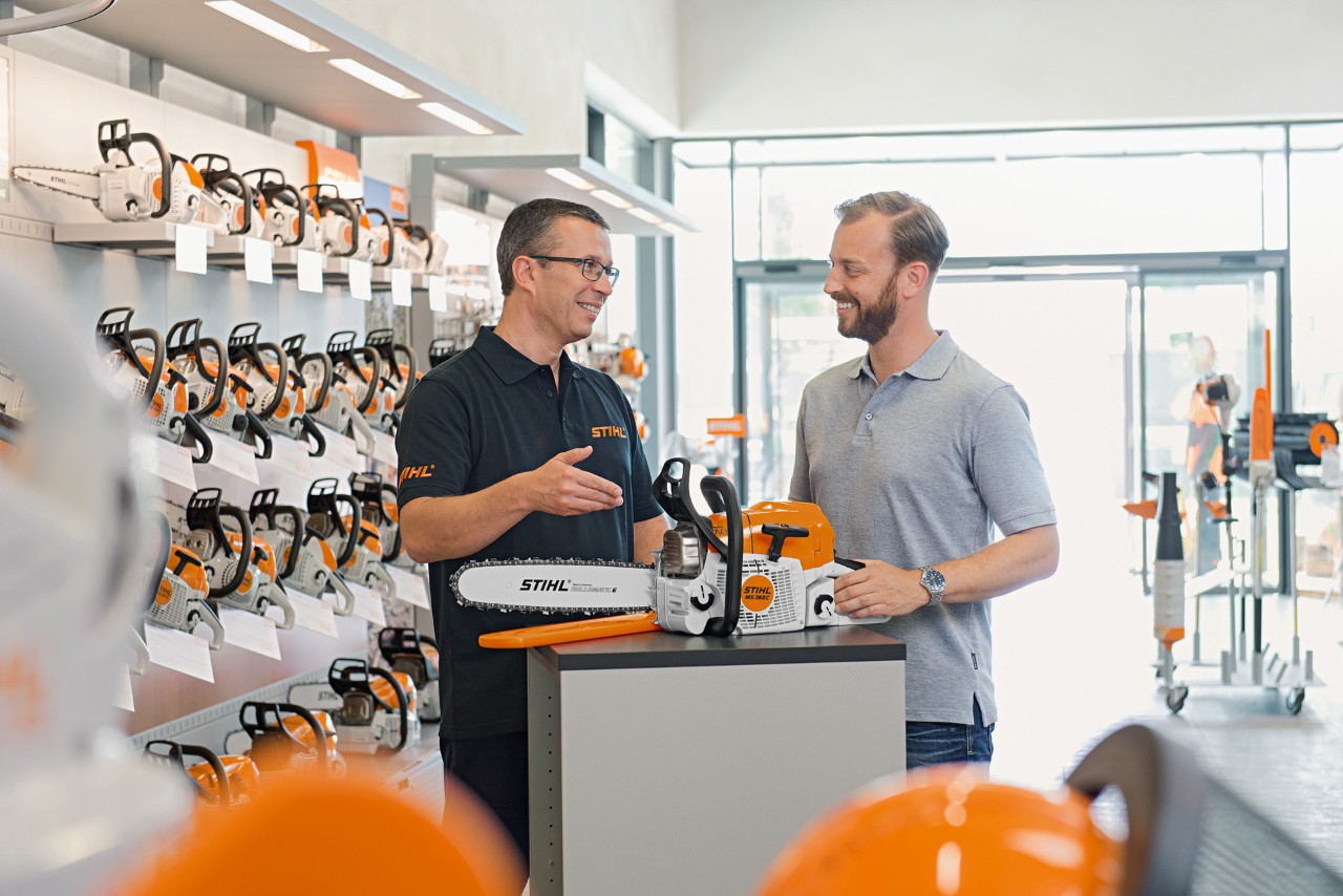 STIHL Fachhändler berät Mann beim Kauf einer STIHL Kettensäge