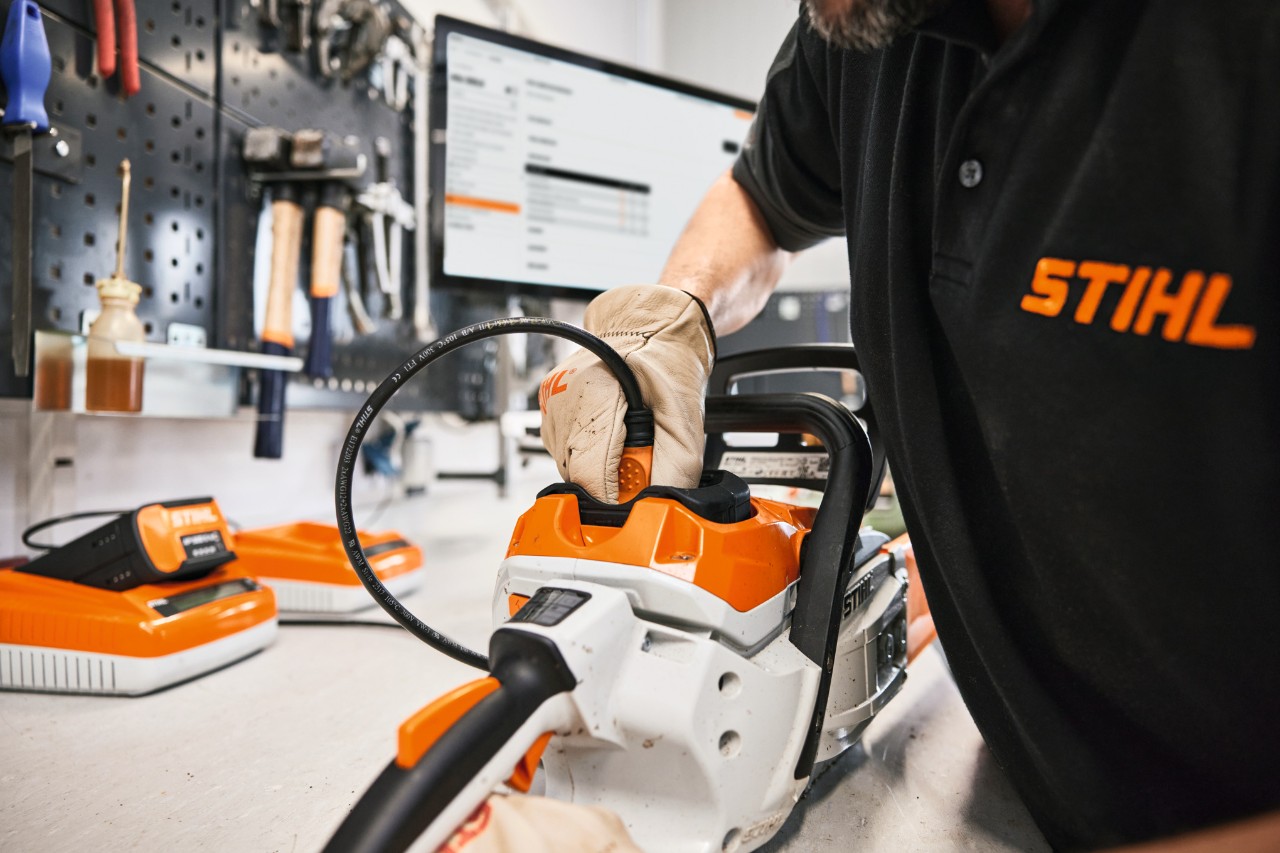 STIHL Mitarbeiter oder Fachhändler repariert eine Motorsäge