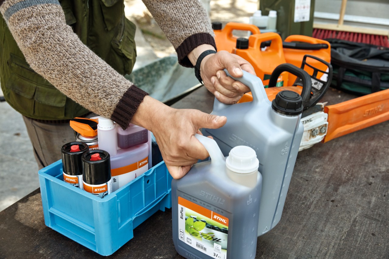 Eine Person räumt STIHL Betriebsstoffe in Kisten zum Transport 