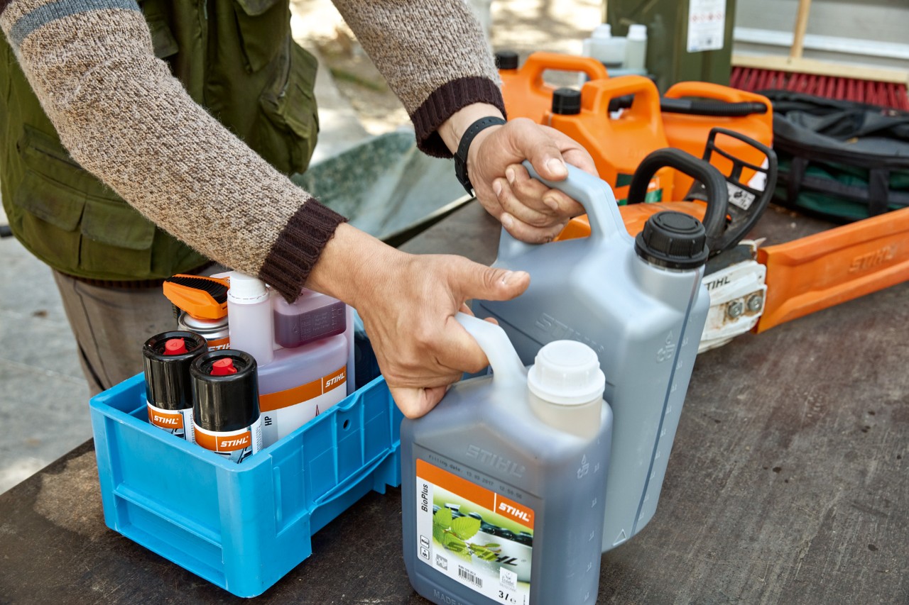 Eine Person räumt STIHL Betriebsstoffe in Kisten zum Transport