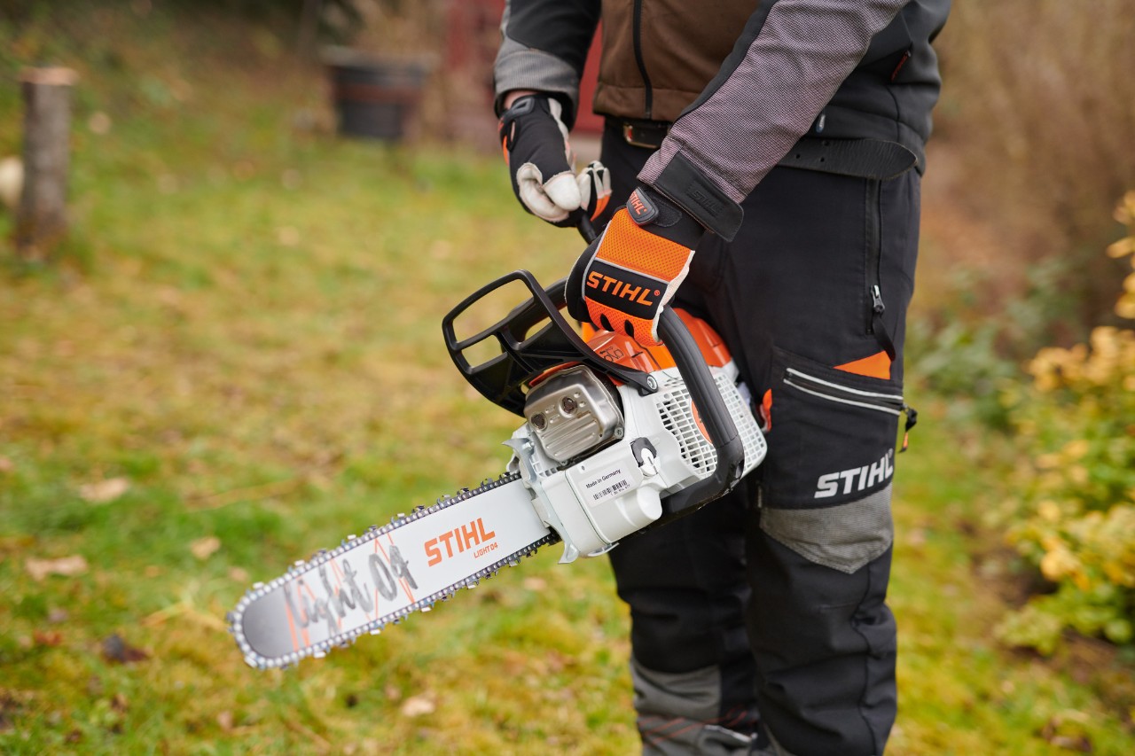 Mann in Schutzausrüstung startet STIHL Benzin-Kettensäge mit ElastoStart und Führungsschiene Light 04